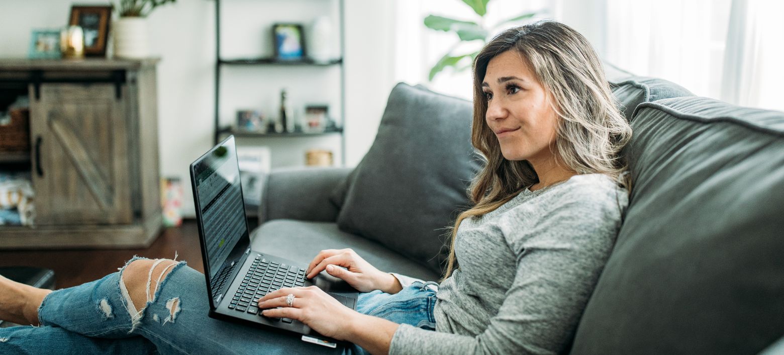 Frau mit Laptop auf der Couch